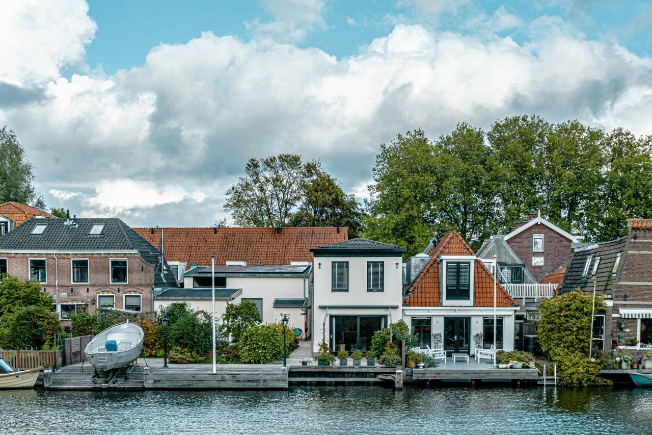 a small boat in a body of water in front of a house